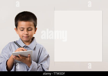 Jeune garçon portant ses pères shirt faisant semblant d'être homme d'affaires avec les appareils numériques et un stylo. L'éducation de la petite enfance, l'apprentissage de l'image concept jouer avec adde Banque D'Images