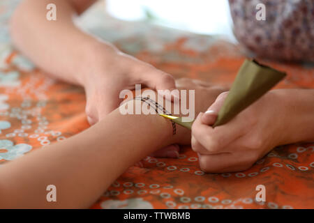 Maîtresse de dessin de tatouage tatouage au henné sur la main féminine, gros plan Banque D'Images