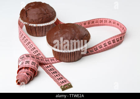 Délicieux muffins au chocolat avec un ruban à mesurer sur le tableau blanc Banque D'Images