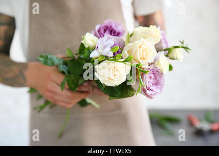 Male florist holding bouquet flower shop Banque D'Images