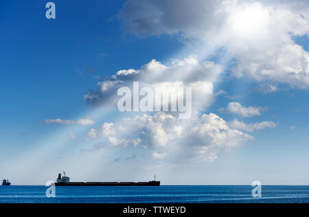 Deux conteneurs vides dans la Méditerranée avec le ciel bleu, les nuages et rayons de soleil Banque D'Images