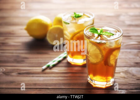 Verres de thé glacé avec les tranches de citron et menthe sur fond de bois Banque D'Images