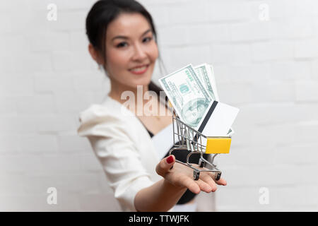 Close up businesswoman holding panier avec carte de crédit et l'US dollar Banque D'Images