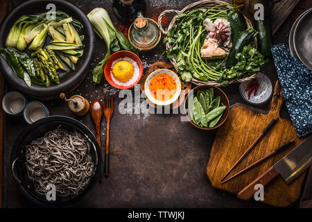 Arrière-plan de l'alimentation asiatique. Végétarien savoureux ingrédients. Divers légumes verts, nouilles soba - nouilles de sarrasin, la saveur du sel et le piment hot sauce sur r Banque D'Images