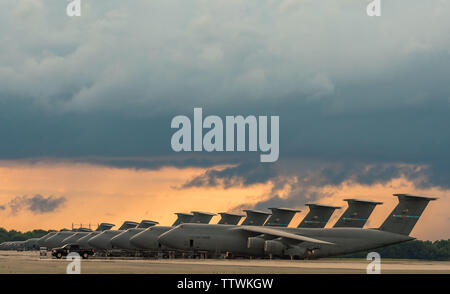 Comme un orage s'approche par l'ouest, C-5M Super Galaxies et C-17A Globemaster III s'asseoir sur la ligne de vol le 13 juin 2019 à Dover Air Force Base, Del. Il y a 18 C-5ms et 13 C-17comme affecté à Douvres. (U.S. Air Force photo de Roland Balik) Banque D'Images