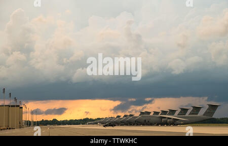 Comme un orage s'approche par l'ouest, C-5M Super Galaxies et C-17A Globemaster III s'asseoir sur la ligne de vol le 13 juin 2019 à Dover Air Force Base, Del. Il y a 18 C-5ms et 13 C-17comme affecté à Douvres. (U.S. Air Force photo de Roland Balik) Banque D'Images