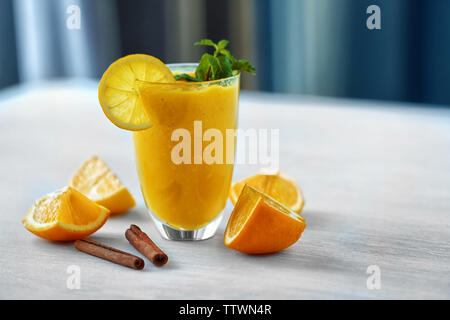 Verre de lait à l'orange délicieux sur table lumineuse Banque D'Images