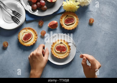 Femme avec fourchette et couteau prêt à manger fig cake, vue du dessus Banque D'Images