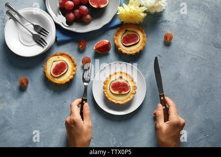 Femme avec fourchette et couteau prêt à manger fig cake, vue du dessus Banque D'Images