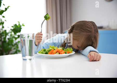 Petite fille refuse de manger une salade de légumes Banque D'Images