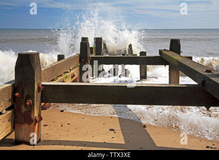 Vue de la mer se briser contre un brise-lames en bois sur la côte de Norfolk à Panier vide, Happisburgh, Norfolk, Angleterre, Royaume-Uni, Europe. Banque D'Images