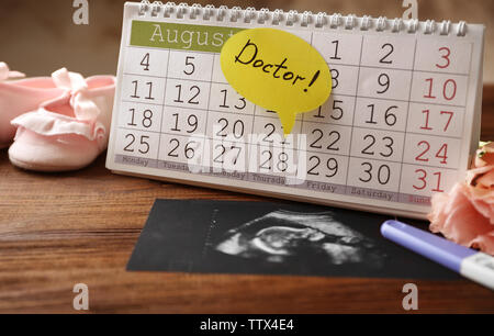 Calendrier avec échographie de bébé sur fond de bois Banque D'Images