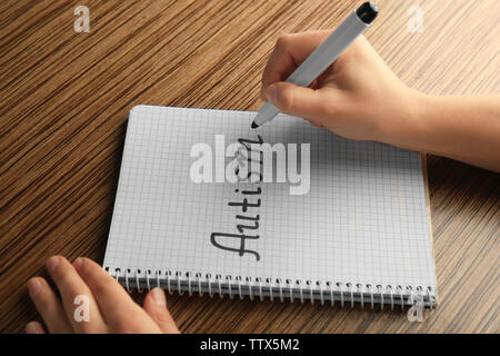 La main de l'ordinateur portable dans l'autisme mot écrit Banque D'Images