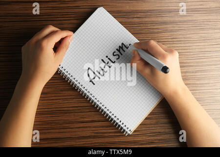 La main de l'écrit dans l'autisme mot portable, vue d'en haut Banque D'Images