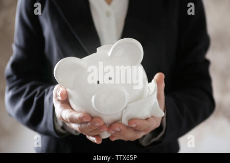 Woman holding broken piggy bank Banque D'Images