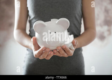 Woman holding broken piggy bank Banque D'Images