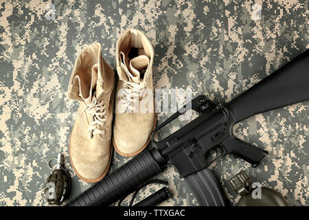 Ensemble de l'équipement militaire et des bottes de combat sur fond de camouflage Banque D'Images