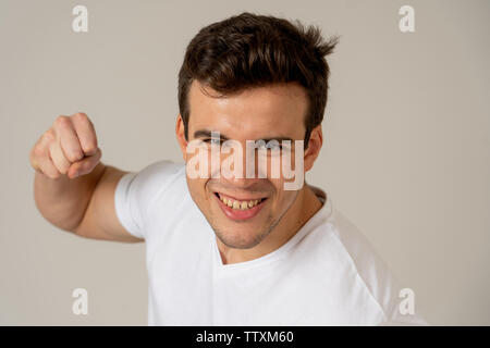 Jeune homme séduisant en rage à la position de défense en furieux et menacer avec perforation en poing en colère et bouleversé l'expression visage fou ba gris isolé Banque D'Images