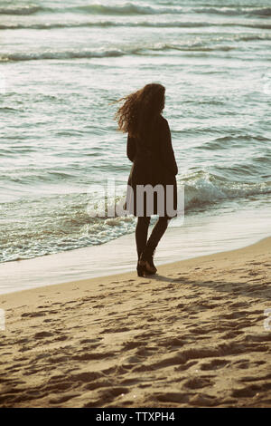 Jeune femme marche sur la plage Banque D'Images