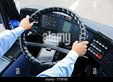 Mains de chauffeur de bus sur le volant Banque D'Images