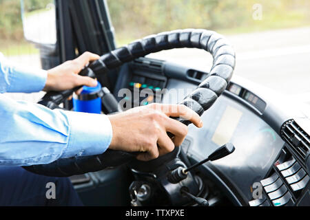 Mains de chauffeur de bus sur le volant Banque D'Images