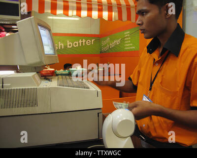 Vendeur utilisant un ordinateur à un comptoir de caisse, Inde Banque D'Images