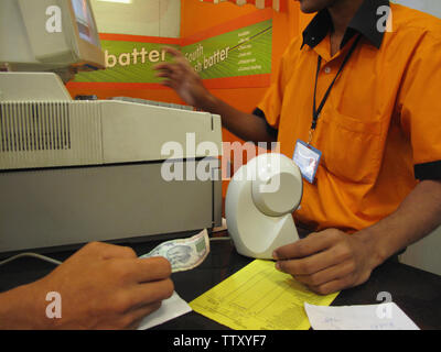 Vendeur utilisant un ordinateur à un comptoir de caisse, Inde Banque D'Images