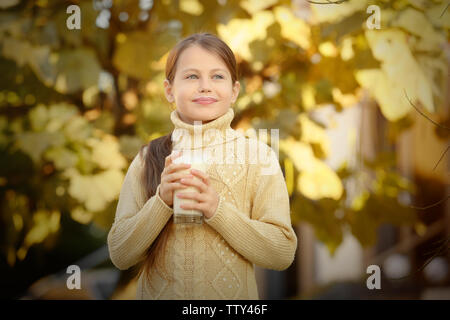 Cute little girl avec verre de lait frais piscine Banque D'Images