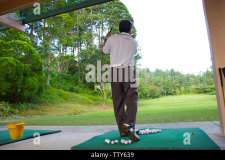 Homme pratiquant le golf à l'aire d'échauffement Banque D'Images