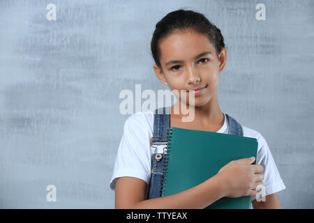 Cute schoolgirl sur un fond de couleur Banque D'Images