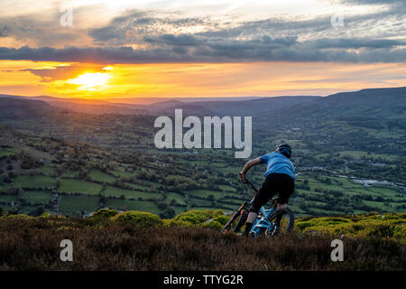 Un homme rides un ebike depuis le sommet de l'Ardanaiseig dans les Brecon Beacons, près d'Abergavenny, Monmouthshire, Wales. Randonnée cycliste du Pays de Galles. Banque D'Images