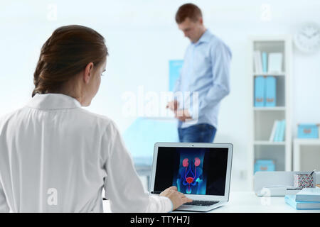 Concept médical. Le médecin à l'écran de l'ordinateur portable avec l'image du système d'urologie Banque D'Images