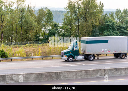 Cabine de jour green classic populaires de qualité industrielle puissante semi gros camion camion transportant du fret commercial en bref van sec s'exécutant sur la semi-remorque Banque D'Images