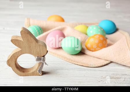 Bunny la figure et les oeufs de Pâques colorés sur table en bois Banque D'Images