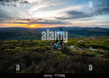 Un homme rides un ebike depuis le sommet de l'Ardanaiseig dans les Brecon Beacons, près d'Abergavenny, Monmouthshire, Wales. Randonnée cycliste du Pays de Galles. Banque D'Images