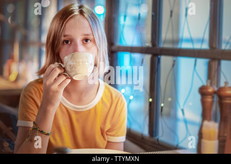 Jolie jeune fille à boire le thé dans le restaurant Banque D'Images