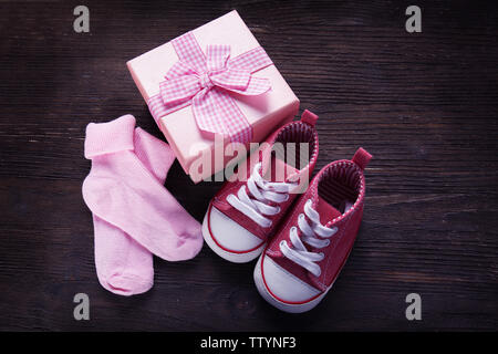 Nouvelle chaussure pour enfant avec boîte-cadeau et chaussettes sur fond de bois Banque D'Images