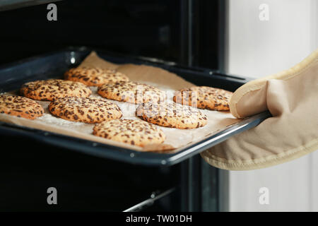 Woman taking out biscuits fraîchement cuits au four Banque D'Images