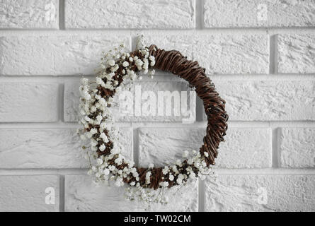 Couronne de fleurs avec de belles fleurs blanches sur fond de mur de briques Banque D'Images