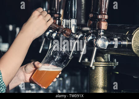 Woman pouring bière froide dans un verre au bar, gros plan Banque D'Images