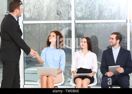 Concept d'entrevue d'emploi. Manager shaking woman's hand in office hall Banque D'Images