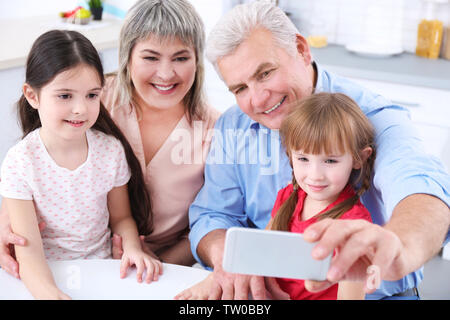 Grand parents avec peu de filles prenant selfies Banque D'Images