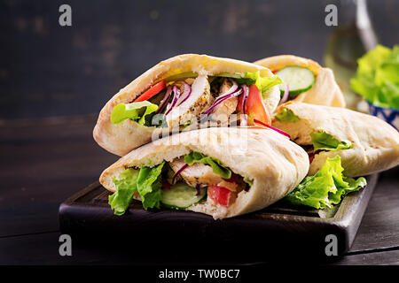 Pita au poulet, tomate et laitue sur fond de bois. Une cuisine du Moyen-Orient. Banque D'Images