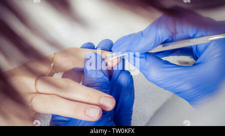 Traitement des ongles de doigt, le meulage et le polissage en instituts de beauté. Processus manucure Banque D'Images