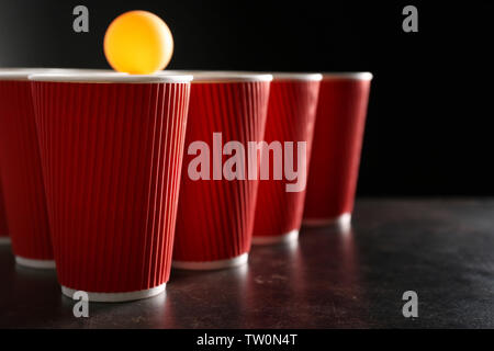 Beer Pong en plastique tasses et ball, gros plan Banque D'Images