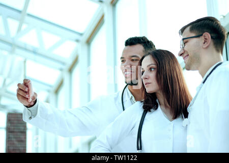 Groupe de médecins stagiaires en tenant vos autoportraits dans le hall de l'hôpital. Les gens et la technologie Banque D'Images
