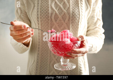 Les mains avec de la glace en dessert rose bol cristal, gros plan Banque D'Images