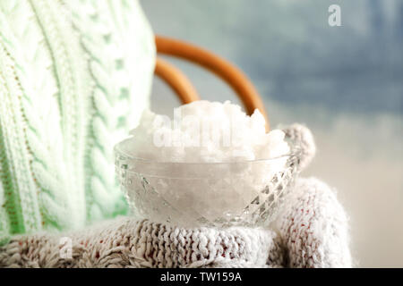 Les mains dans les moufles holding bowl cristal de neige closeup Banque D'Images