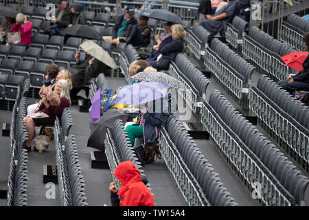 La Queens Club, London, UK. 18 juin 2019. Jour 2 championnats de la Fever Tree, la pluie annule tous les jouer sur 2 jours en laissant les spectateurs s'abritant sous des parasols. Credit : Malcolm Park/Alamy Live News. Banque D'Images