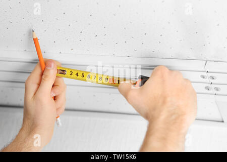 Les mains des hommes faisant des mesures de rideau Banque D'Images